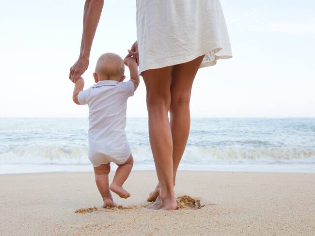 Madre con un bebé en la playa.